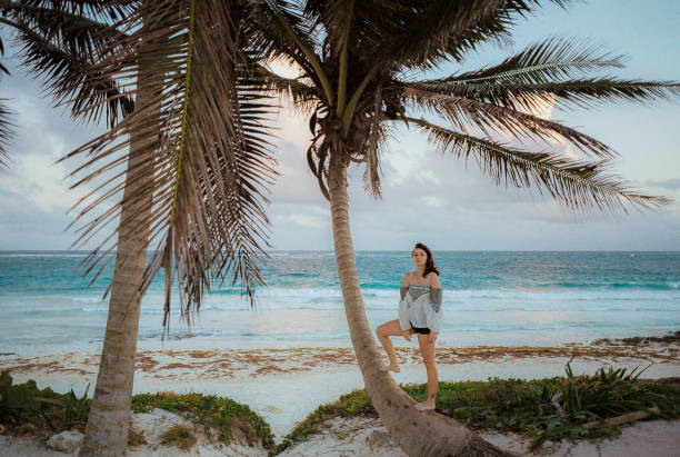 istock Woman on the beach in Tulum. Standing on palm tree 1392347254