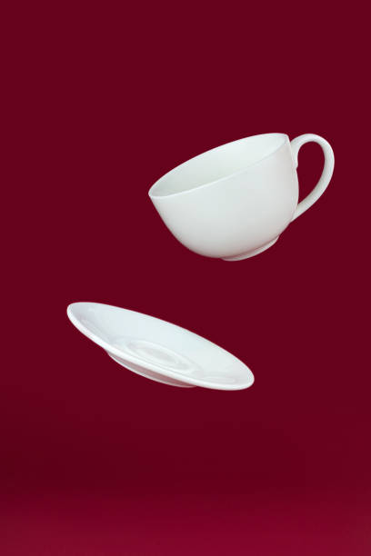 istock Flying Cup with saucer on red background. 1392348732