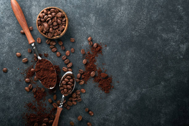 istock Coffee beans background. Roasted coffee concept with differents types of beans and cinnamon sticks on dark black stone background. Top view. Coffee concept. Mock up. 1392349652