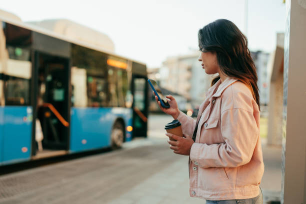 istock Woman using phone at bus station 1392350845