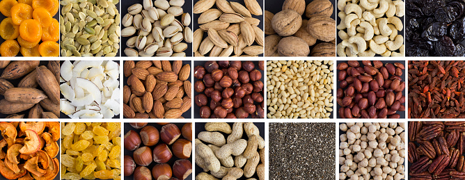 Stock photo showing close-up, elevated view of four small dishes containing an assortment of nuts and seeds. The top-right dish is filled with almonds, while the others (moving clockwise) contain white sunflower seeds, cashew nuts and pumpkin seeds, also known as pepita. These nuts offer important individual health benefits when they are eaten as part of a healthy, balanced diet.