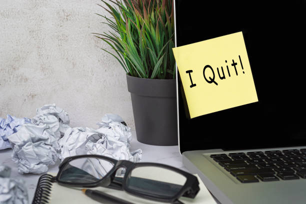 I quit text on sticky note on laptop . Concept of decision making to quit job. stock photo