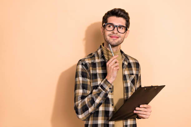 istock Photo of pensive puzzled guy executive hold clipboard decide startup solution isolated pastel color background 1392358068