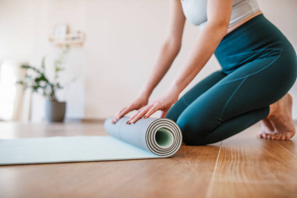 donna che finisce la pratica dello yoga. - materassino foto e immagini stock