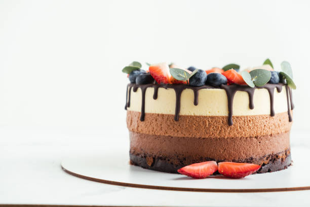 istock Brown layered cake Three chocolates decorated with bluberries, strawberries and chocolate drips on top. 1392359767