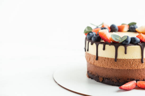 istock Brown layered cake Three chocolates decorated with bluberries, strawberries and chocolate drips on top. 1392359772