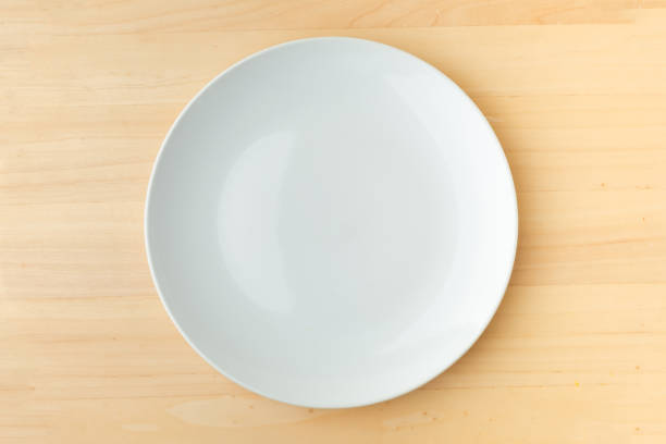 istock Empty white plate on wooden table. background for restaurant menu 1392359773