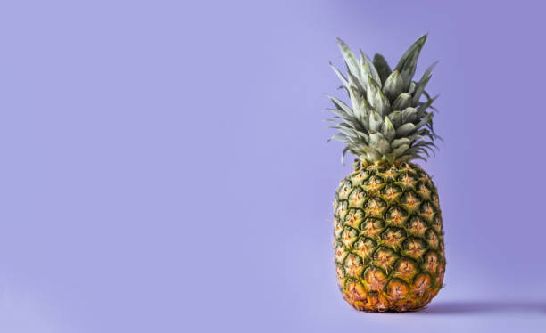 istock Whole pineapple on the purple background 1392359790