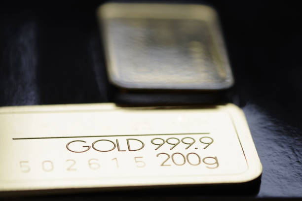 istock Minted gold bar weighing 200 grams against a blurred background. 1392359956