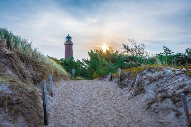 Way from the beach through sand dunes to the lighthouse at sunrise at Darßer Ort in Fischland Darß Zingst