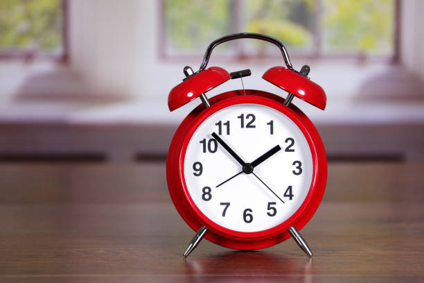 istock Red traditional alarm clock in room differential focus 1392361726