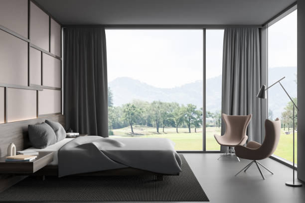 istock Brown bedroom interior with bed on carpet, window with countryside 1392364127