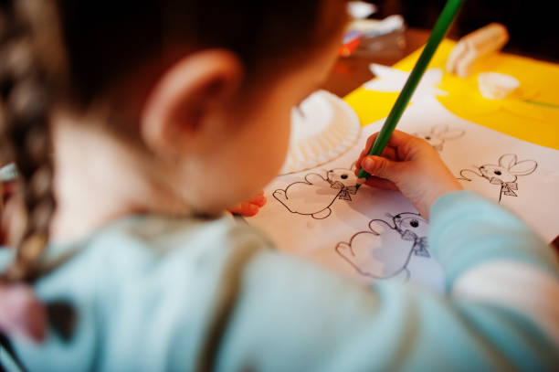 istock Preparing to Easter concept. Little girl drawing bunny. 1392365111