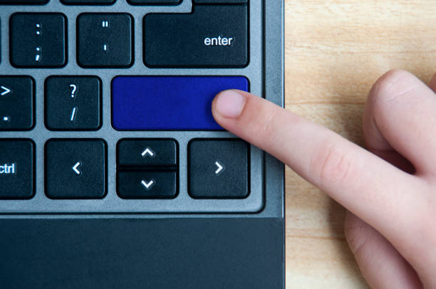 istock Top view of hand pressing blank blue button on laptop keyboard. Copy space concept 1392367570