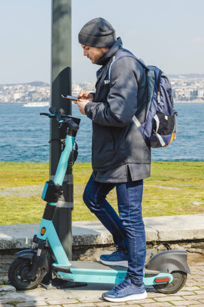 istock Man scanning code with his smartphone for renting electric scooter, mobility as a service sharing system. 1392367906