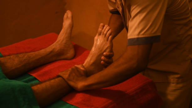 hombre que tiene terapia de curación ayurveda para masaje de relajación de pies - chakra ayurveda recovery herbal medicine fotografías e imágenes de stock