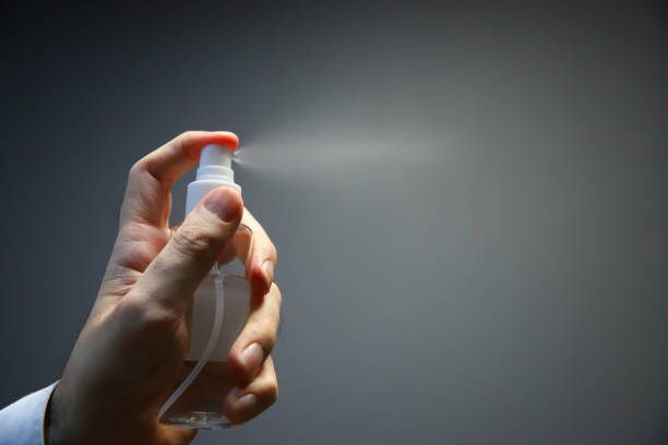 istock spraying disinfectant on gray background. isolated hand using spray. 1392370193