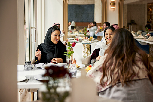 Mujeres de Oriente Medio disfrutando de la comida en el restaurante del hotel photo