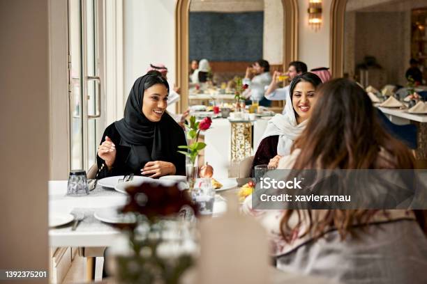 Middle Eastern Women Enjoying Meal In Hotel Restaurant Stock Photo - Download Image Now