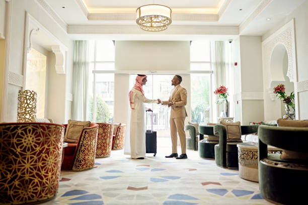 Saudi businessman shaking hands with client in hotel lobby