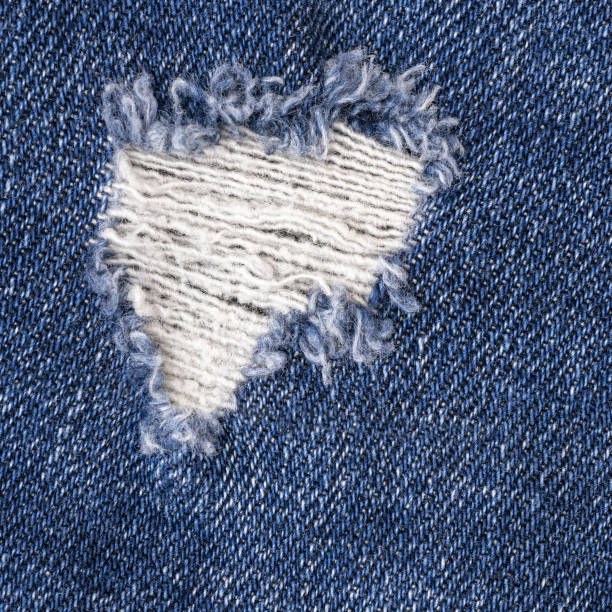 Closeup of torn old blue jeans background. texture of ripped