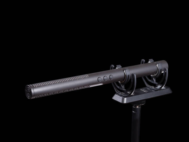 istock Gun microphone on shock mount isolated on black. 1392377194