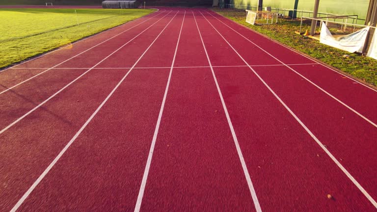 First person view of athele running the running tracks and speeding fast. Stadium with running event