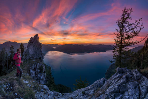 Hiker relaxes on mountain ridge at sunset with fantastic view over the Attersee, seen from Schoberstein Mountain, Nature, Hiking, Landscape - Scenery attersee stock pictures, royalty-free photos & images
