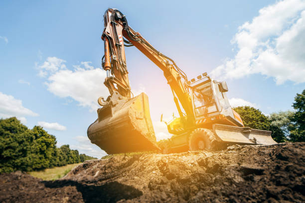 Earth excavator machine working by the roadside. Road service repairs the highway Earth excavator machine working by the roadside. Road service repairs the highway scraper stock pictures, royalty-free photos & images