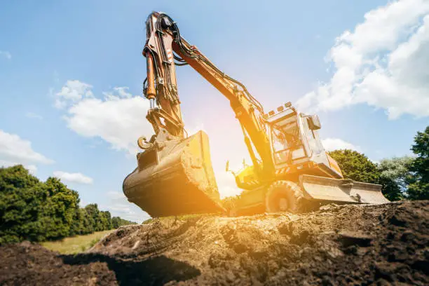 Photo of Earth excavator machine working by the roadside. Road service repairs the highway