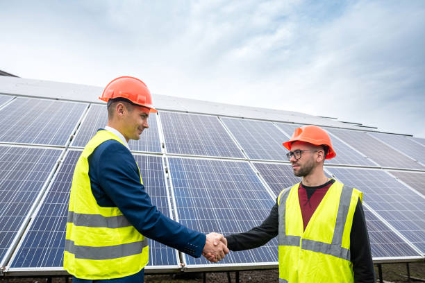 istock Workers in work clothes greet each other by the hand before starting work on solar panels. 1392380752