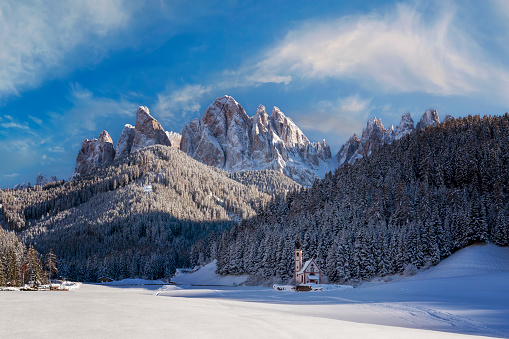 View of mountain peaks, snow and beautiful church in Italy