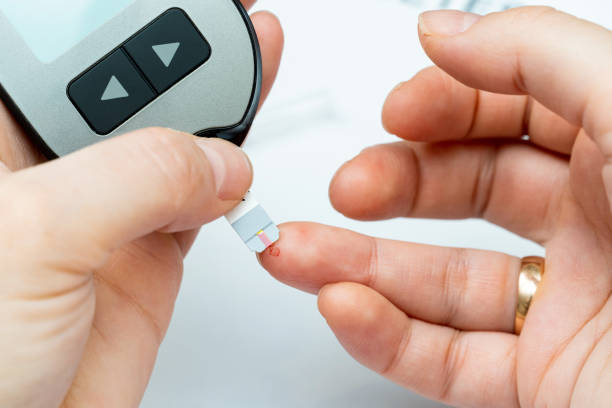 istock Taking blood from finger for sugar level medical test 1392381927