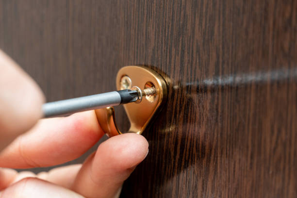 istock screwing the clothes hook to the wardrobe wall with a screwdriver 1392382191