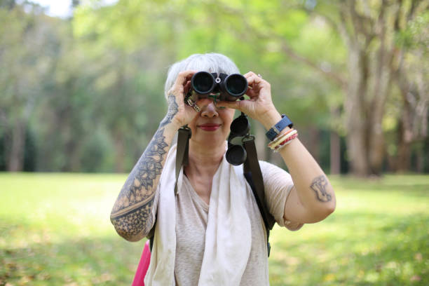 istock senior woman using binoculars to spot animals and things while hiking with backpacks and trekking in the forest. Concept of active lifestyle on retirement. 1392385651