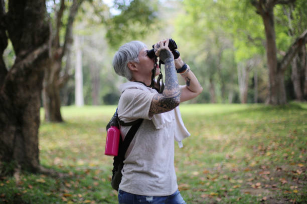 istock senior woman using binoculars to spot animals and things while hiking with backpacks and trekking in the forest. Concept of active lifestyle on retirement. 1392385657