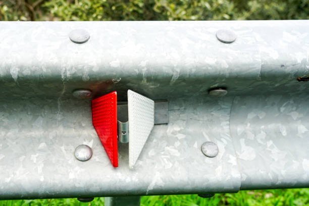 closeup of a profiled metal roadside barrier with a red and white reflector