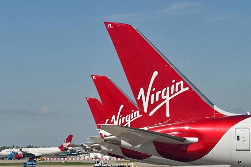 London, England - April 2022:  Tail fins of Virgin Atlantic Airways Boeing jets at the terminal building.