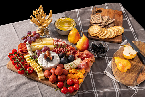 Cured cheese and meze platter setup rich in variety of fruits, cheese, meat and crackers