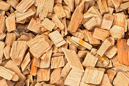 Wooden chips as background, top view. Wood shavings for smoking meat and fish. Wood texture.