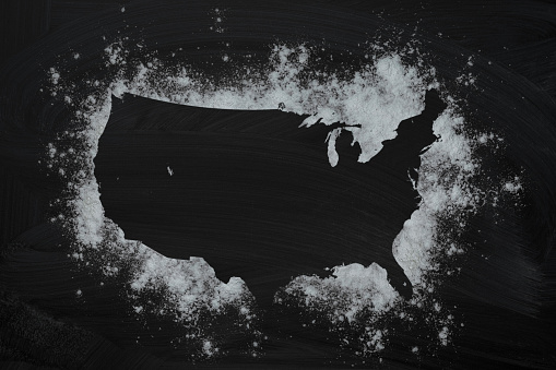 Frame with USA map from the flour on a dark background. Top view, copy space. Food concept.