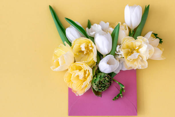 istock Flowers in an envelope on a colored background, flat lay. 1392401051
