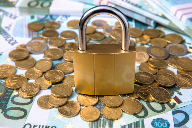 istock lock with coins and dollar on the table. 1392401189