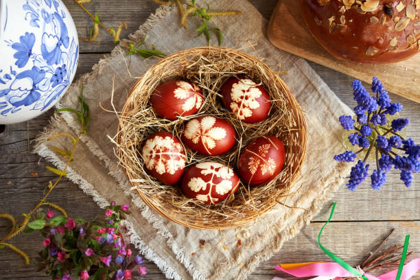 ovos de páscoa em uma cesta com mazanec - doce massa de páscoa semelhante ao pão de cruz quente - bread food basket sweet bun - fotografias e filmes do acervo