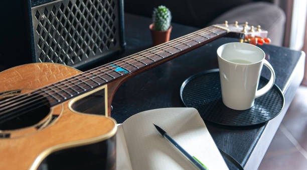 istock Acoustic guitar, notepad and cup, musical creativity concept. 1392402602