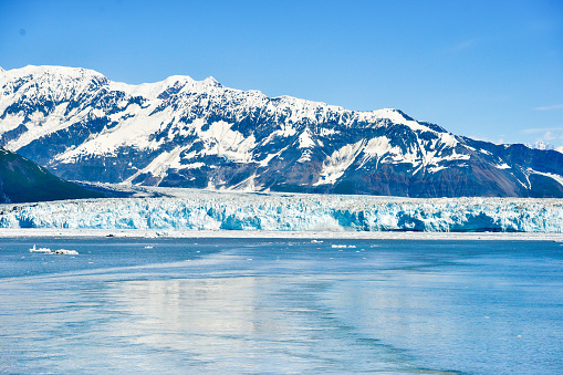 Close up view of the Hubbard Glacier taken from a passing cruise ship, as passengers enjoy seeing the glacier which is threatened by climate change and global warming.