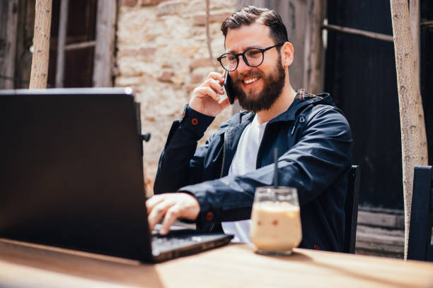 istock Man with glasses working from laptop at outside 1392407515