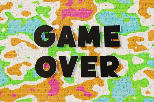 Photo of Game Over! Colorful wall with black letters. Defeated in a computer or board game.