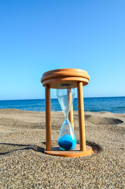 istock Hourglass Clock on the Sand Beach 1392410635