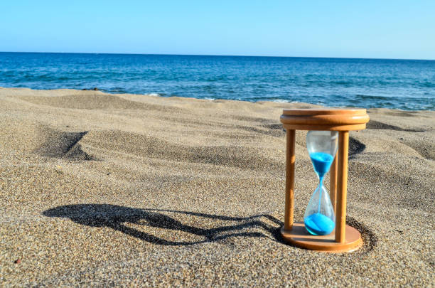 istock Hourglass Clock on the Sand Beach 1392410674